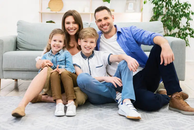 Encantadora Familia Sentada En El Suelo Cerca Del Sofa Posando Casa Piso Sonriendo La Camara Concepto De Padres Y Ninos 193288070 | Pfadt